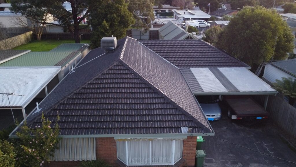 Aerial view of a Melbourne home featuring dark tiled roofing and metal carport roofs, showcasing Top Glaze Roofing Systems expertise in roof repair, replacement, and restoration for tile and metal roofs within a leafy residential neighborhood.