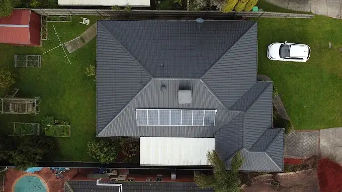 Top view of a house in Melbourne with newly installed solar panels on a dark metal roof.