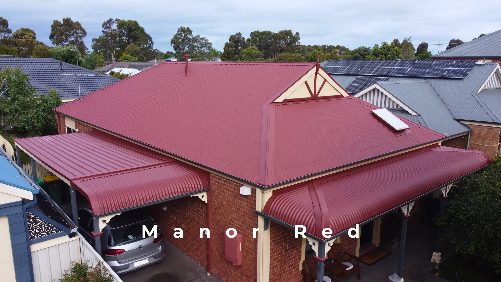 Melbourne roof repair: red metal roofing and carport, aerial view.